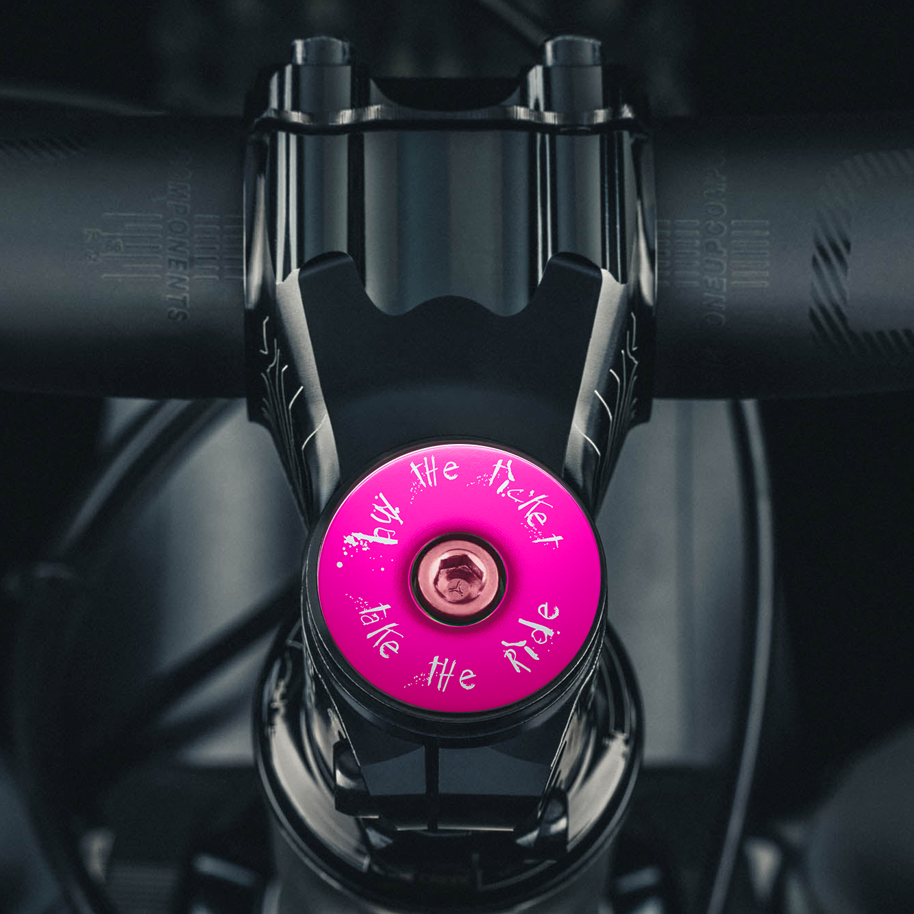 Hot pink headset top cap with engraved design for a stylish ride.