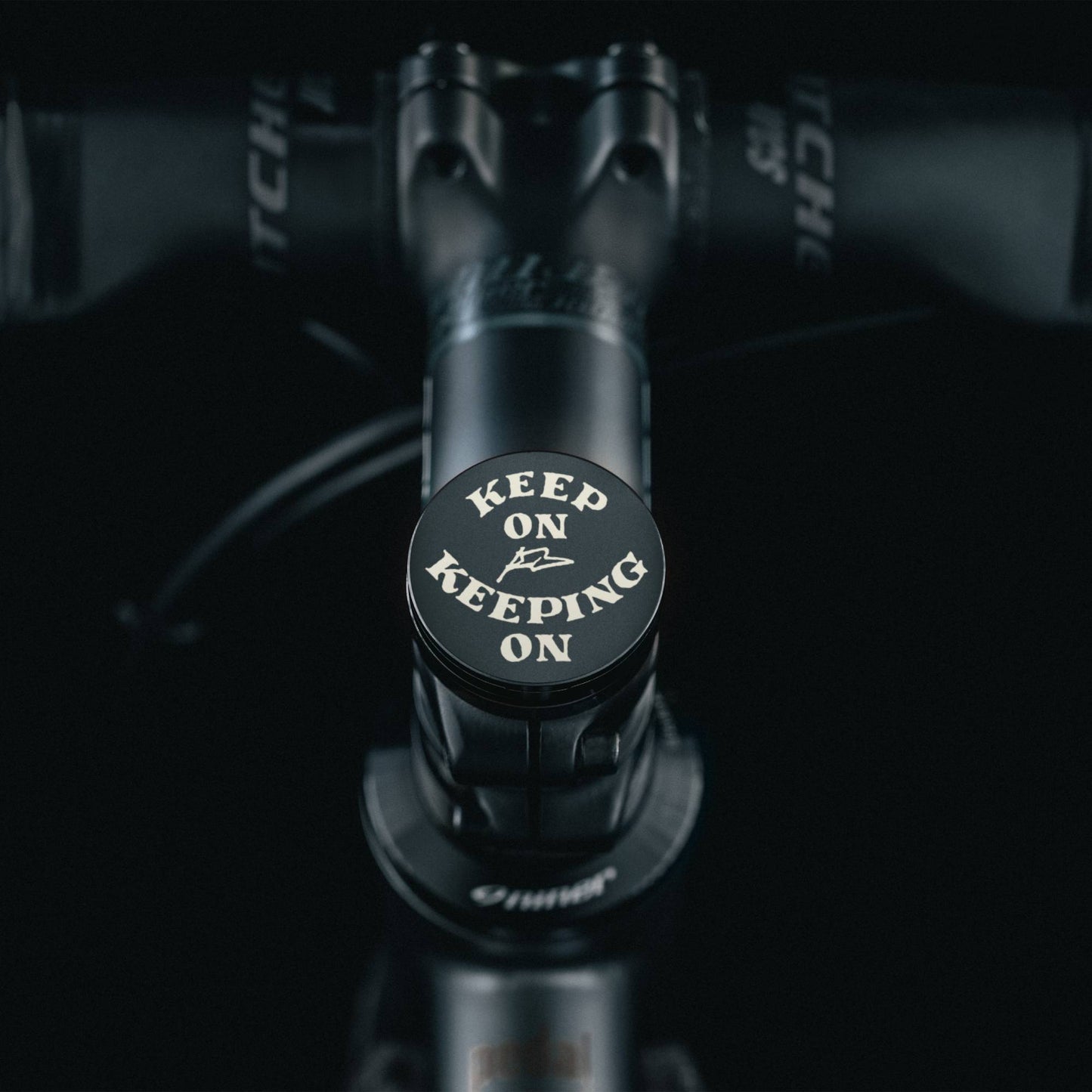 Custom black bike headset cap with a motivational design and flat top cap.