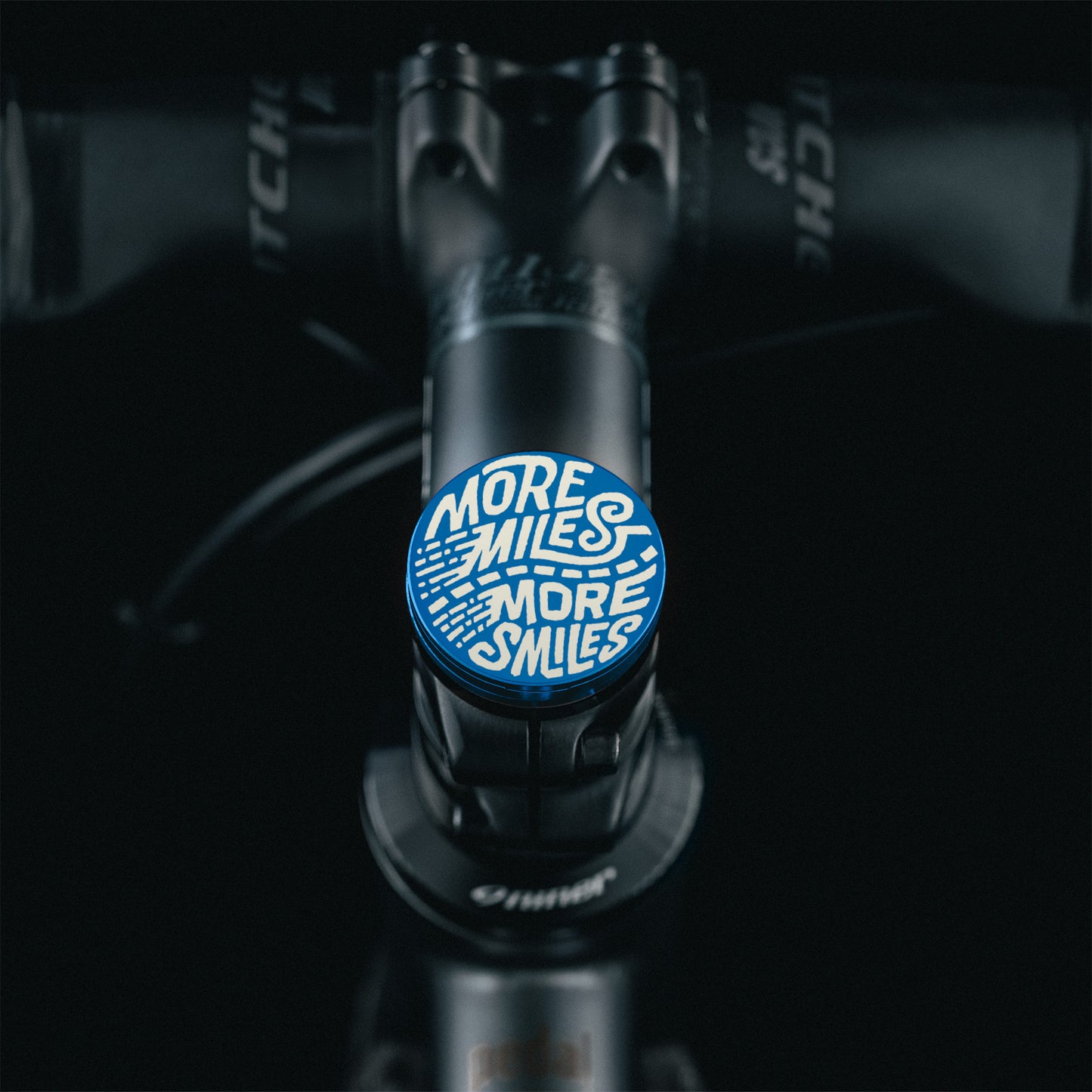 Blue cycling top cap with a unique no-hole design and tool-less installation for custom bicycle setups.