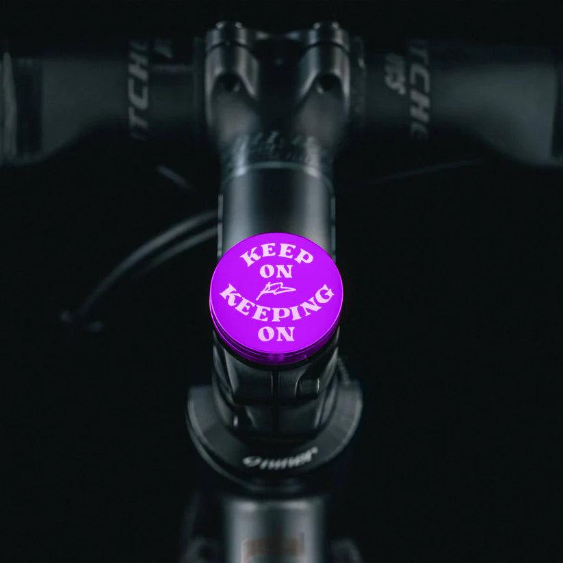 Purple bike top cap with a motivational design and flat top cover.