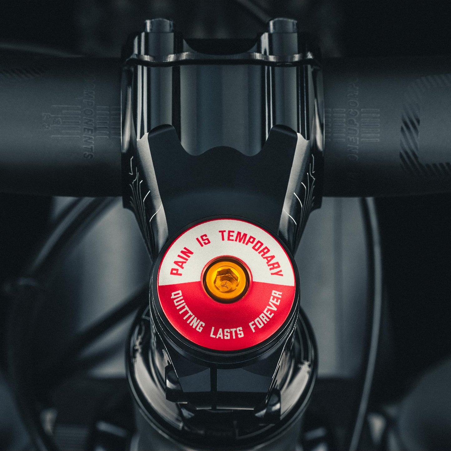 Red bike stem cap with "Pain is Temporary" design for cyclists