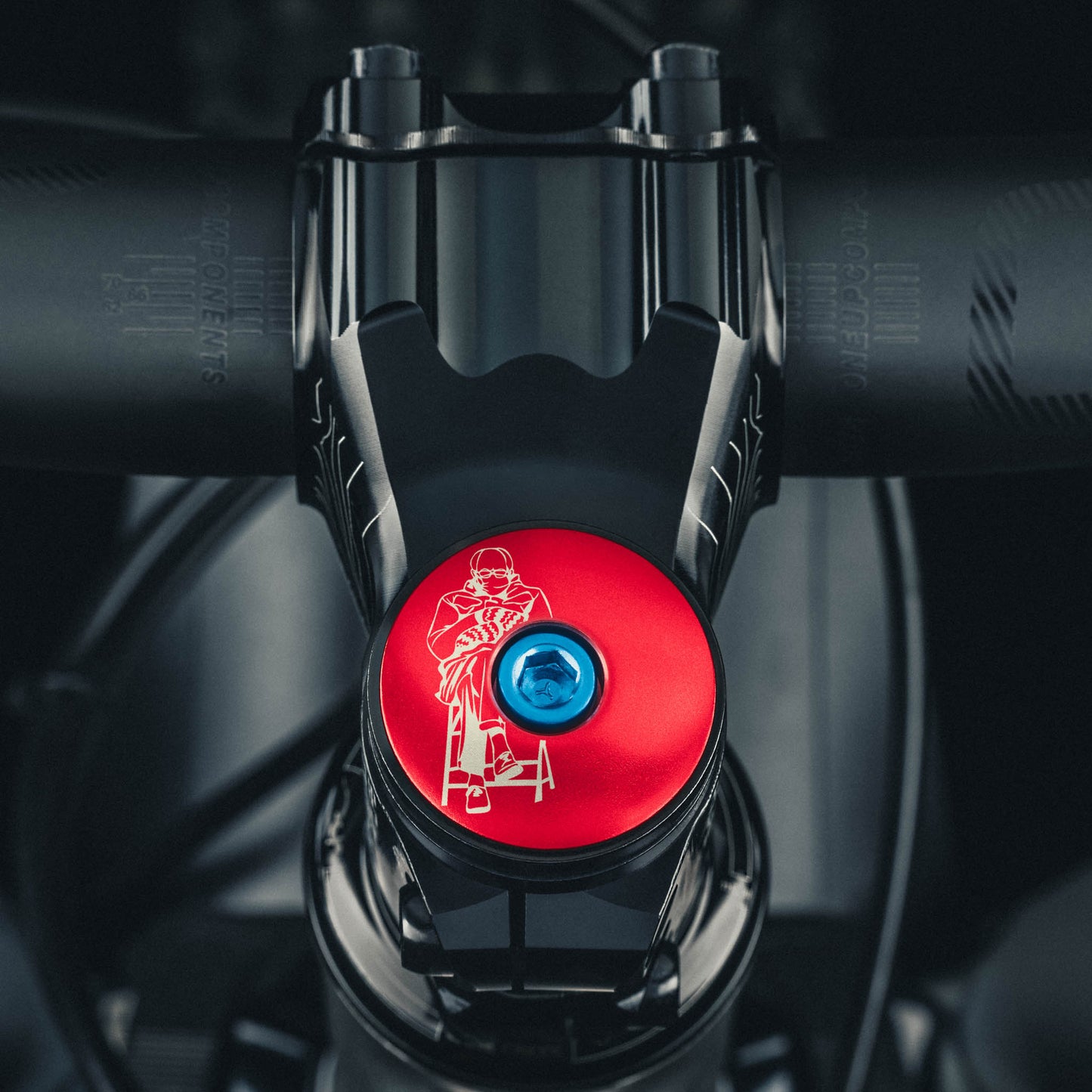 Red custom stem cap with laser engraving for bike components.