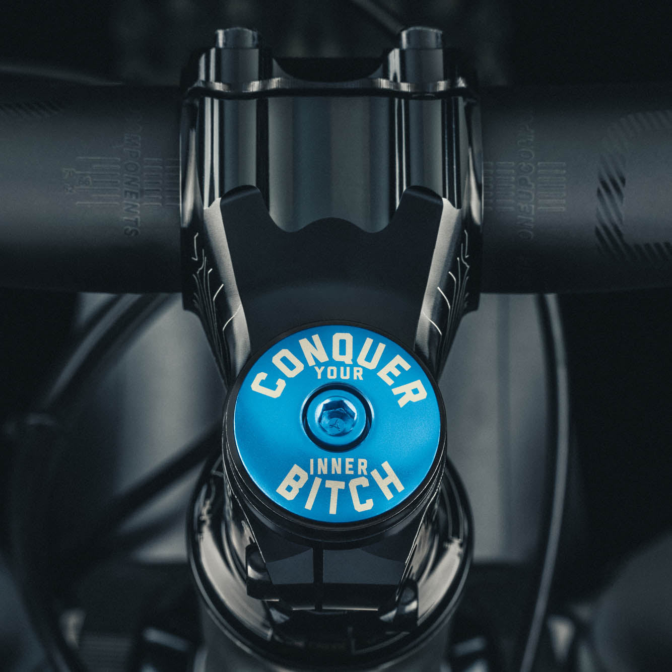 Conquer Your Inner Bitch Custom Vibrant blue bike stem cap designed for cycling enthusiasts seeking personalized bike components.