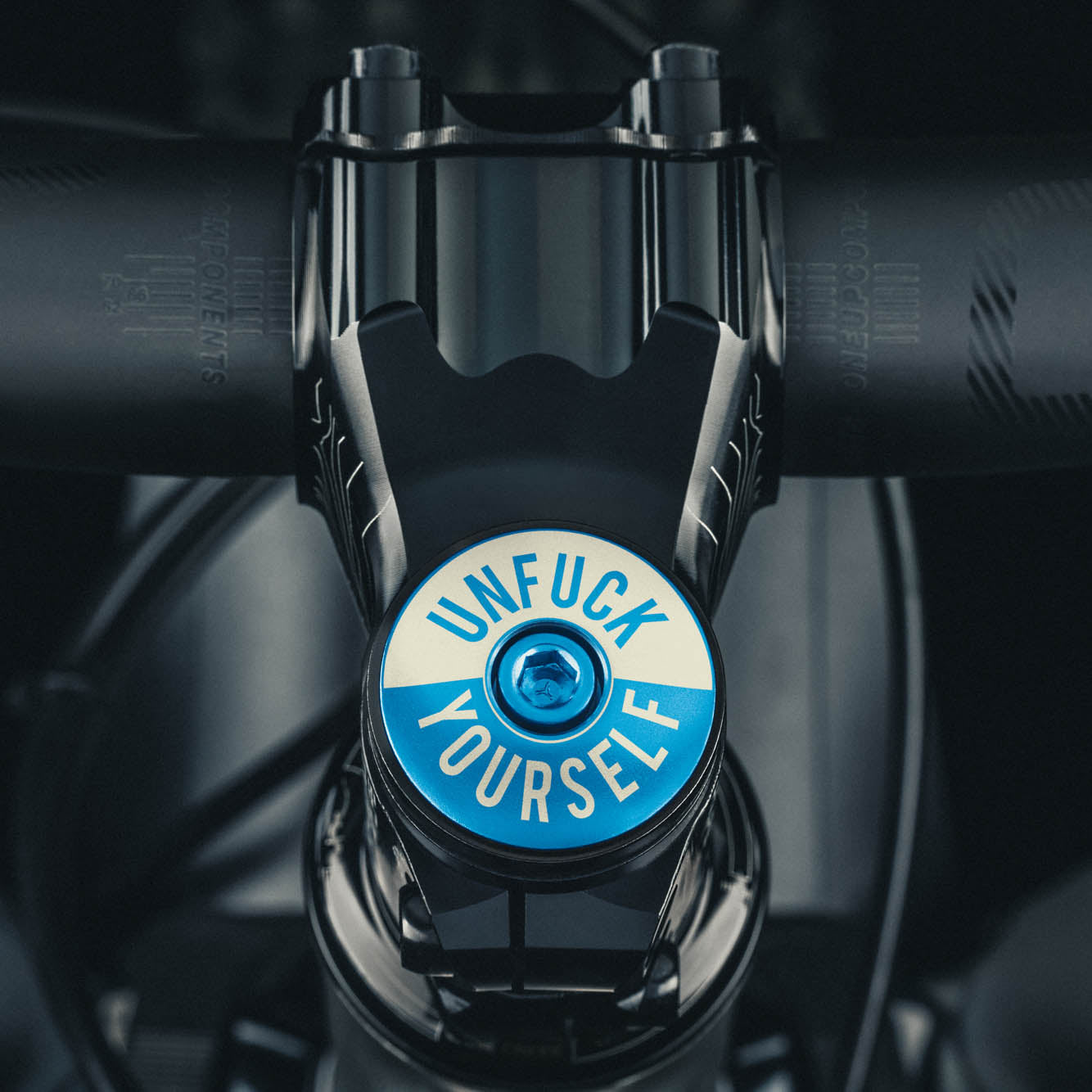 Blue bike headset cap with UNFUCK YOURSELF design for 1 1/8-inch steerer tubes made from durable 6061 aluminum.