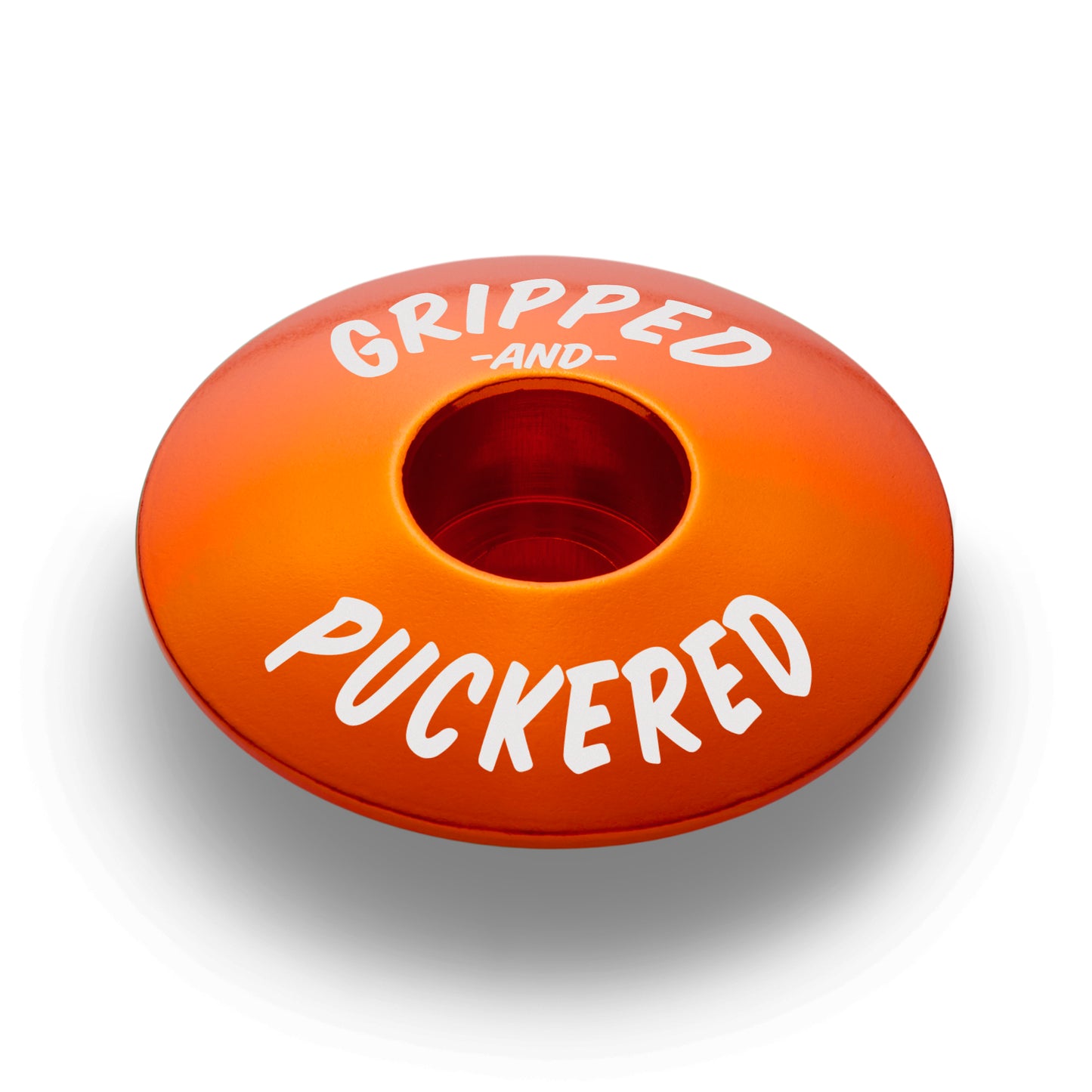 Orange bike stem cap crafted from lightweight aluminum.