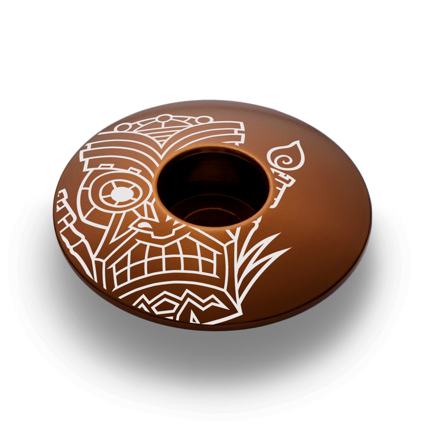 Brown top cap featuring a tiki design for 1 1/8-inch steerer tubes crafted from durable aluminum.