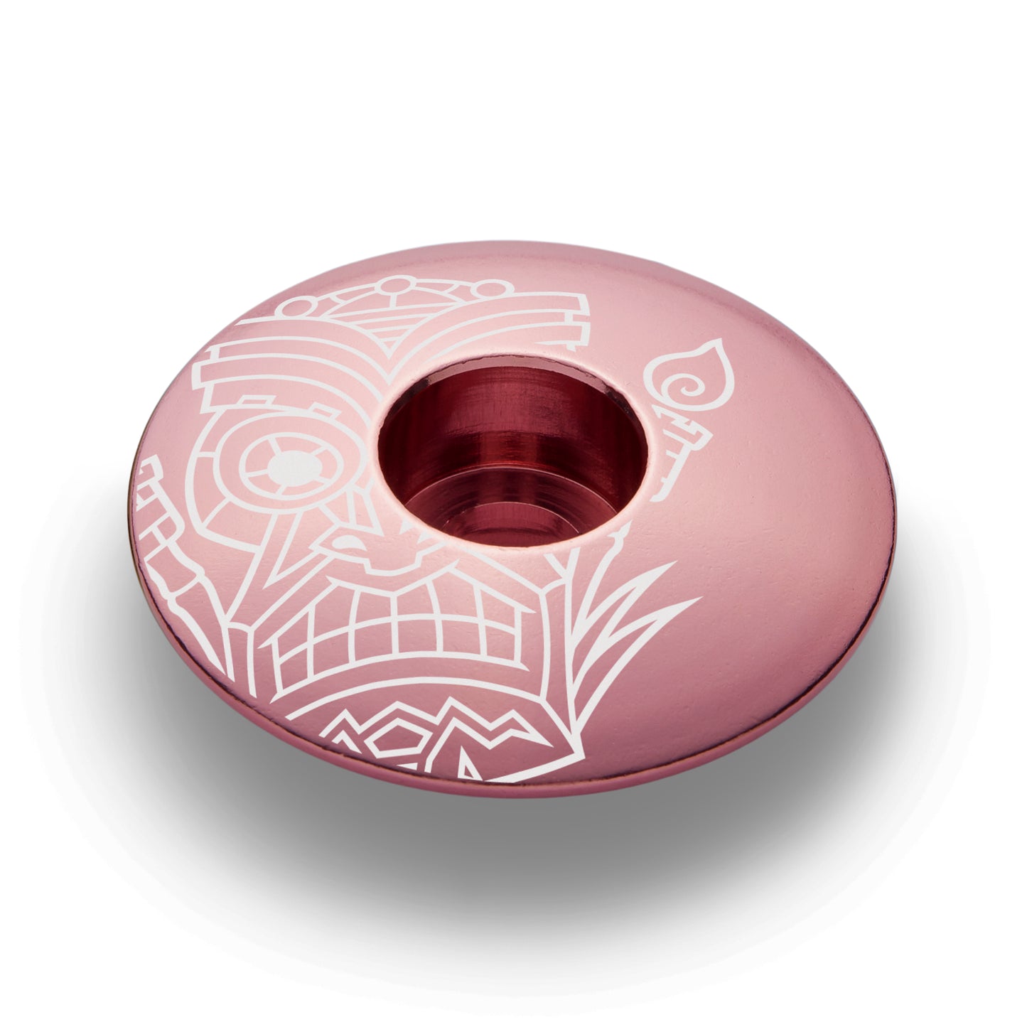 Orange bicycle headset cap with a tiki pattern made of strong and lightweight aluminum.