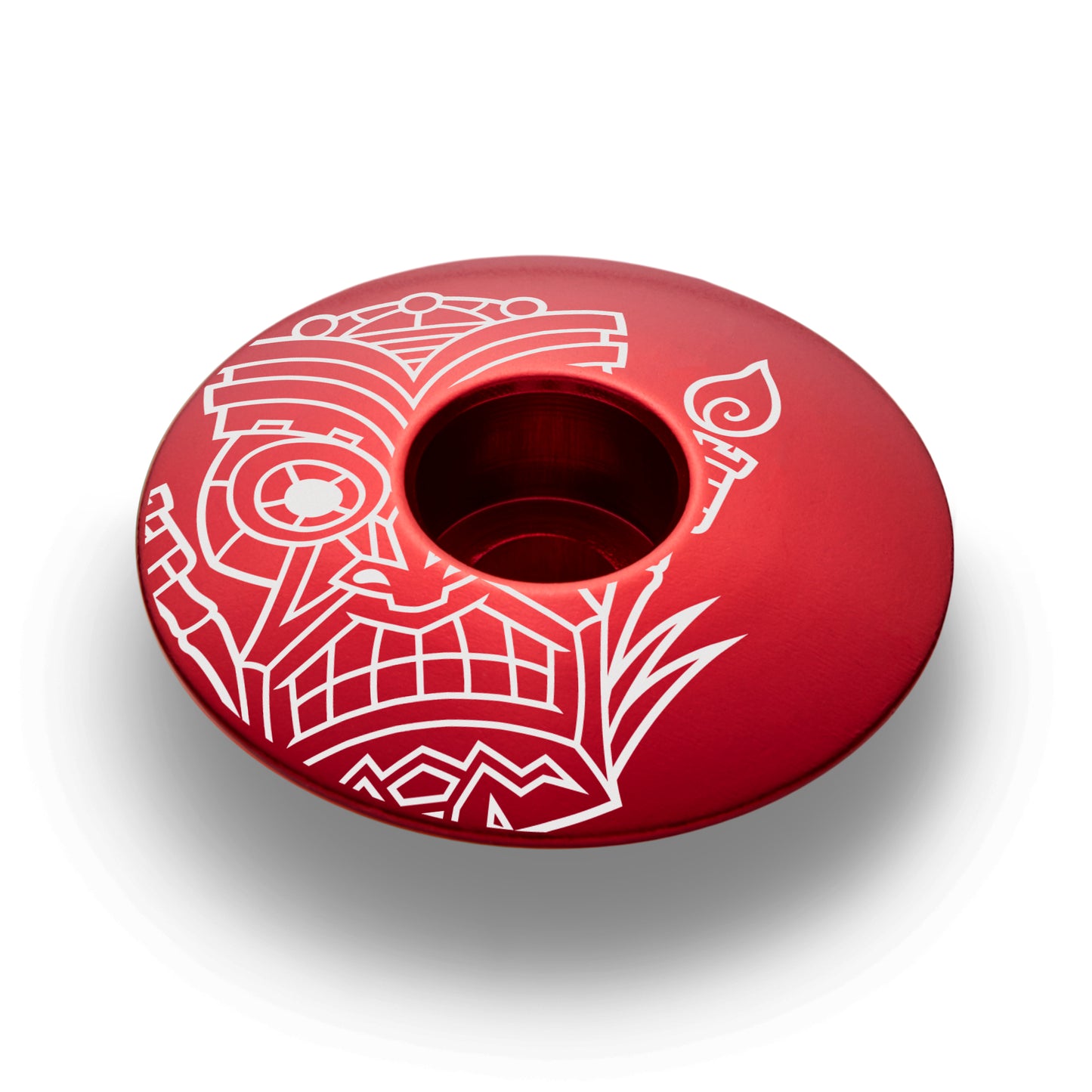 Red bike stem cap featuring a tiki design for 1 1/8-inch steerer tubes made of durable aluminum.