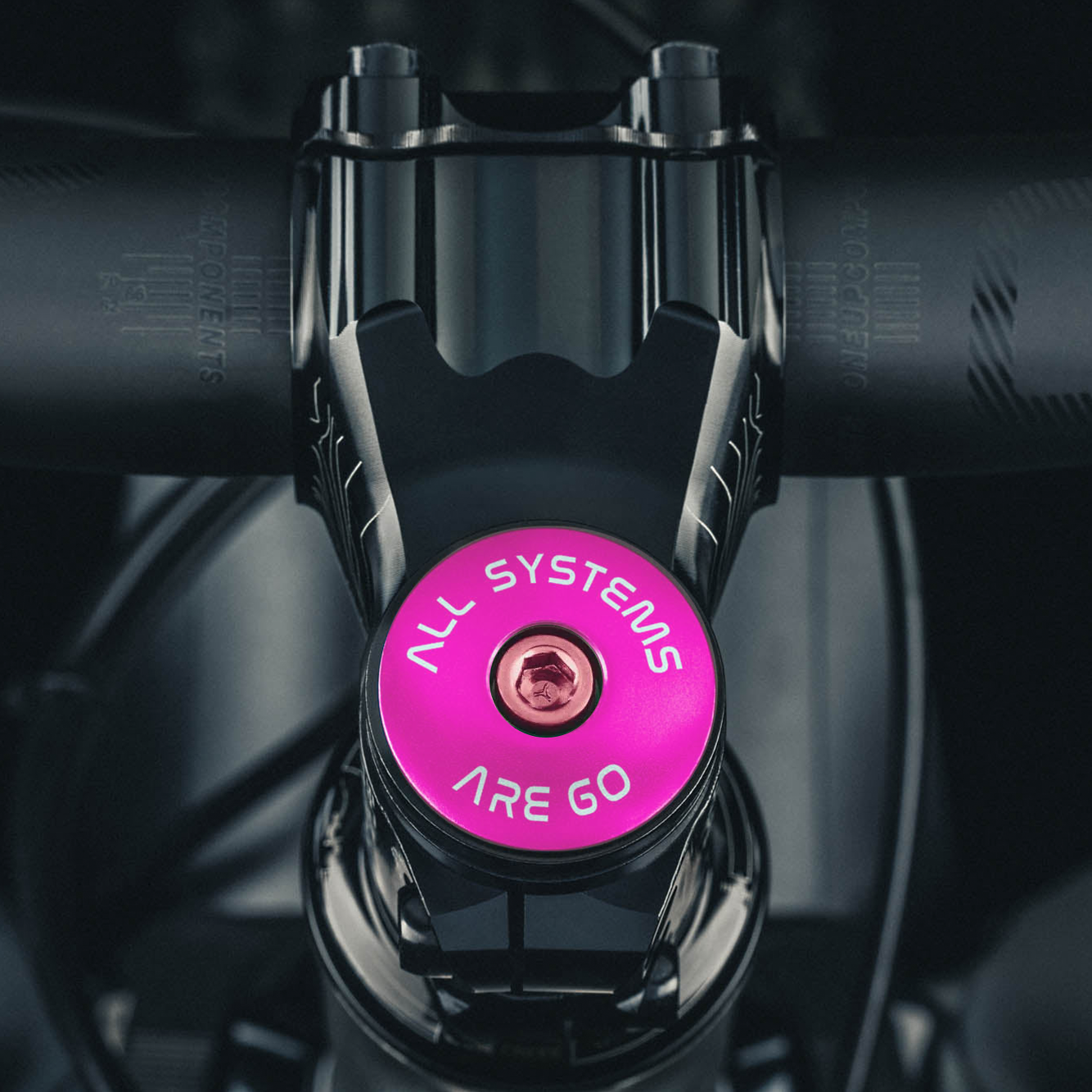 Pink bike headset top cap with laser-engraved "All Systems Are Go" design for cyclists.