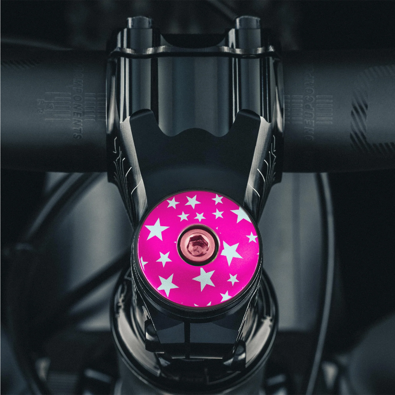 Hot pink star-patterned headset cap for a personal touch on your bike.