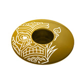 Gold bike headset top cover with a tiki design made of lightweight and durable aluminum.