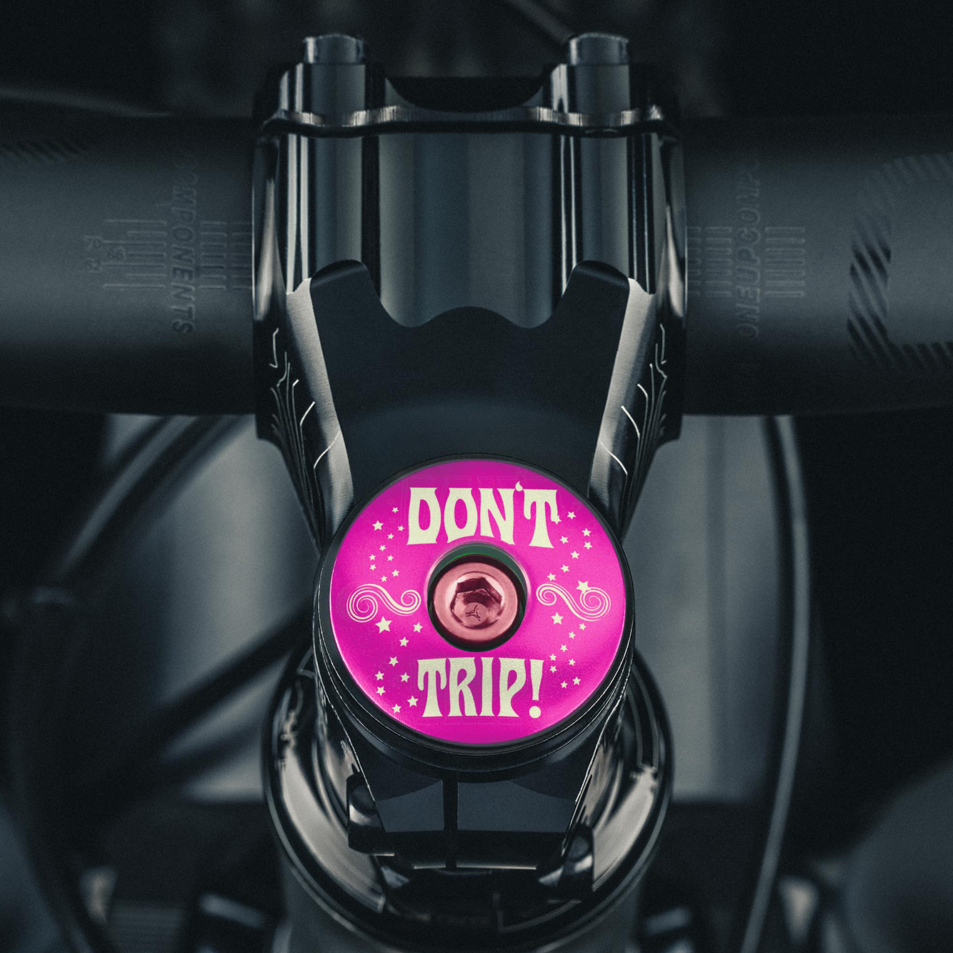 Hot pink stem cap for an eye-catching custom bike component.