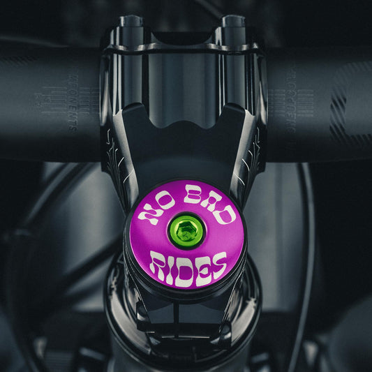 Purple bike stem cap designed with the 'No Bad Rides' message for mountain bikes