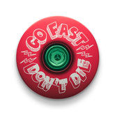Red bike stem cap made from durable 6061 aluminum with Go Fast Don’t Die branding for adventure enthusiasts.