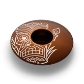 Brown top cap featuring a tiki design for 1 1/8-inch steerer tubes crafted from durable aluminum.