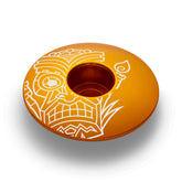 Gold bike headset top cover with a tiki design made of lightweight and durable aluminum.