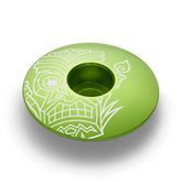 Lime green custom stem cap designed for 1 1/8-inch steerer tubes with a tiki-inspired pattern.