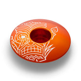 Orange bicycle headset cap with a tiki pattern made of strong and lightweight aluminum.