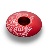 Red bike stem cap featuring a tiki design for 1 1/8-inch steerer tubes made of durable aluminum.
